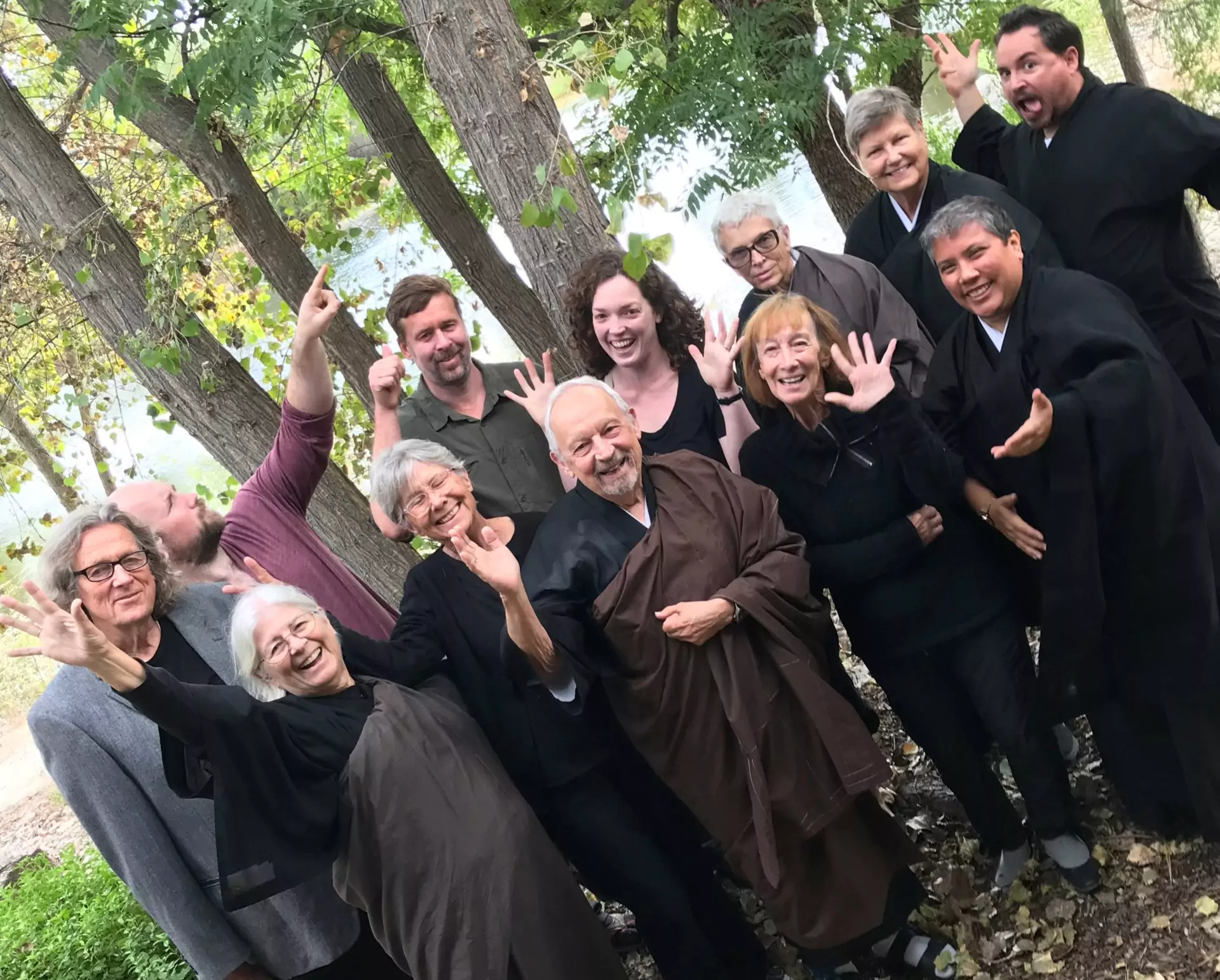 Members of the mountain sanghas in a group photo making a silly pose.
